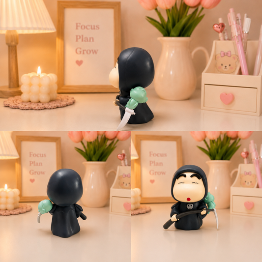 Kawaii Grim Reaper chibi figurine in black robe holding a scythe with mint green floral accent, styled on a pastel desk