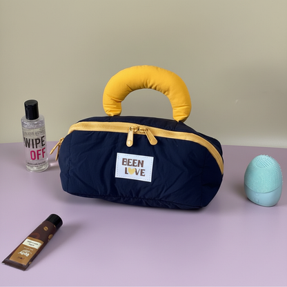 Navy blue quilted travel storage bag with yellow handle and zipper