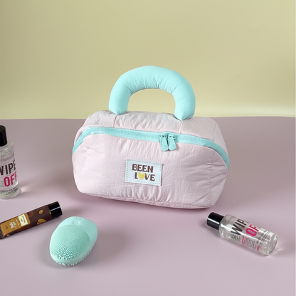 Light pink quilted travel storage bag with mint handle and zipper
